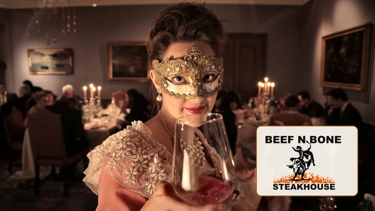 Guest in a gold masquerade mask raising a glass at a candlelit dinner, with the Beef N Bone Steakhouse logo