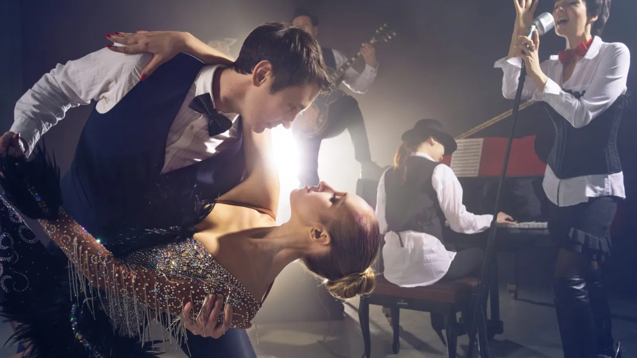 Couple swing dancing in front of a jazz band