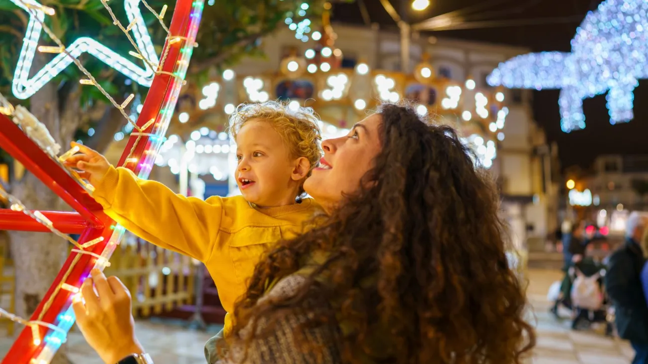 Mother and son admiring Christmas lights at a night market