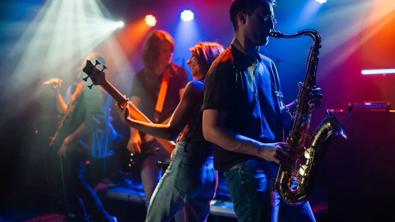 Band playing live on stage under colorful lights