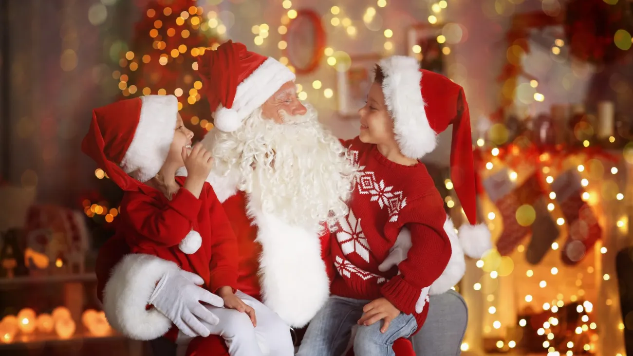 Boy and girl visiting Santa Claus in a decorated room