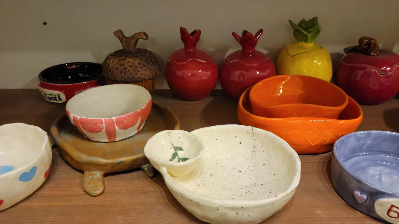 Handmade ceramic dishes on a pottery studio shelf