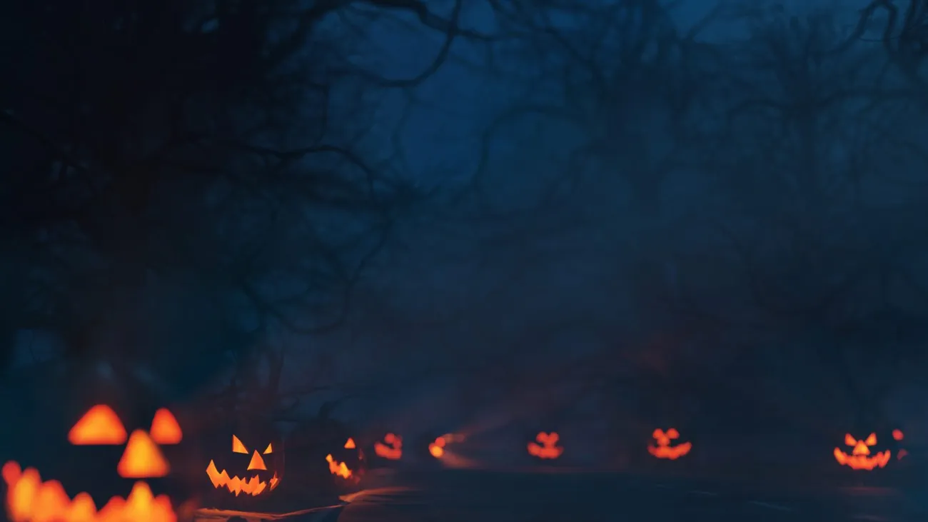 Spooky forest trail at night lined with glowing jack-o-lanterns