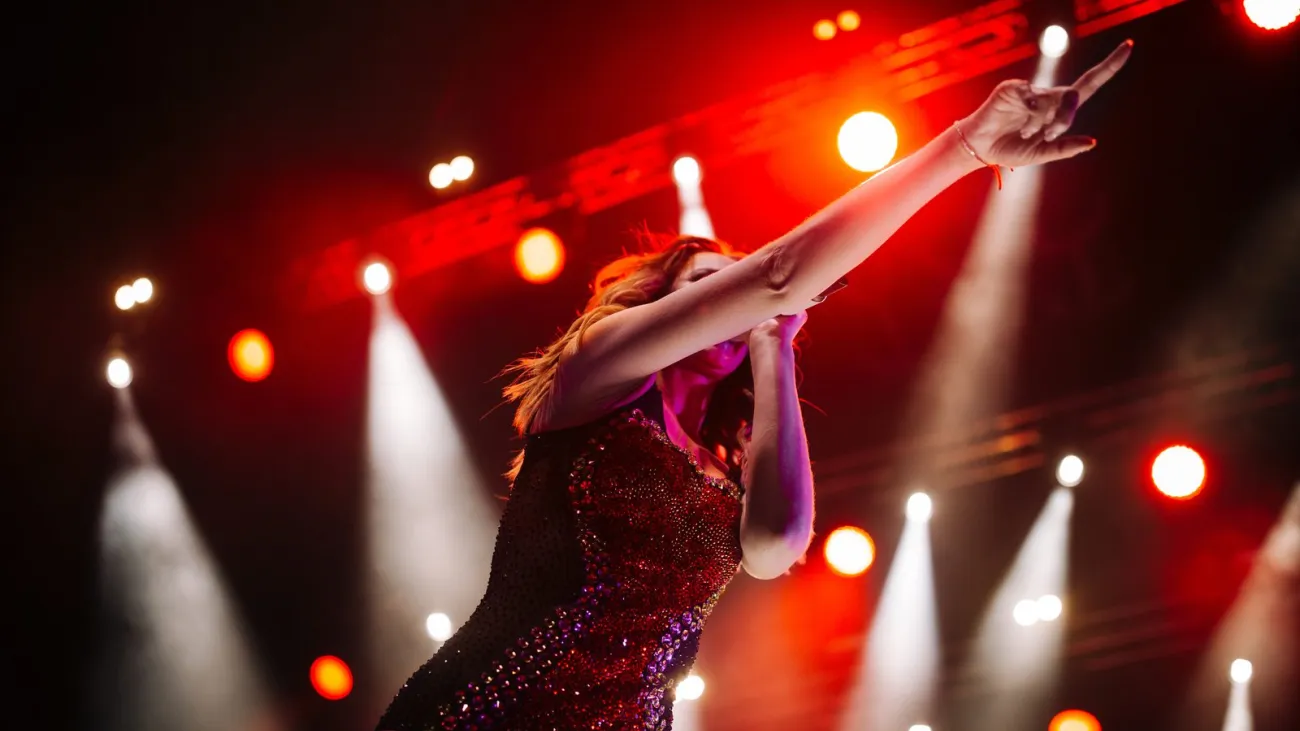 Singer performing on a stage under colorful lights