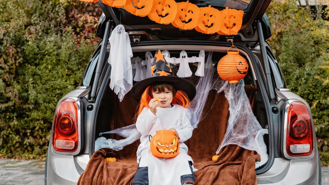 Little child in a witch hat at a trunk or treat