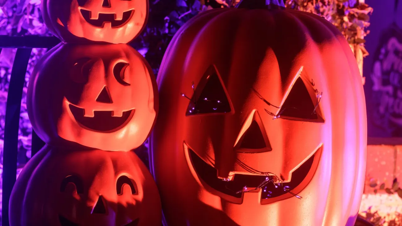 Lit jack-o-lanterns on a porch at night