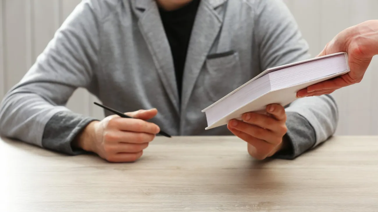 Author signing a copy of a book at a table