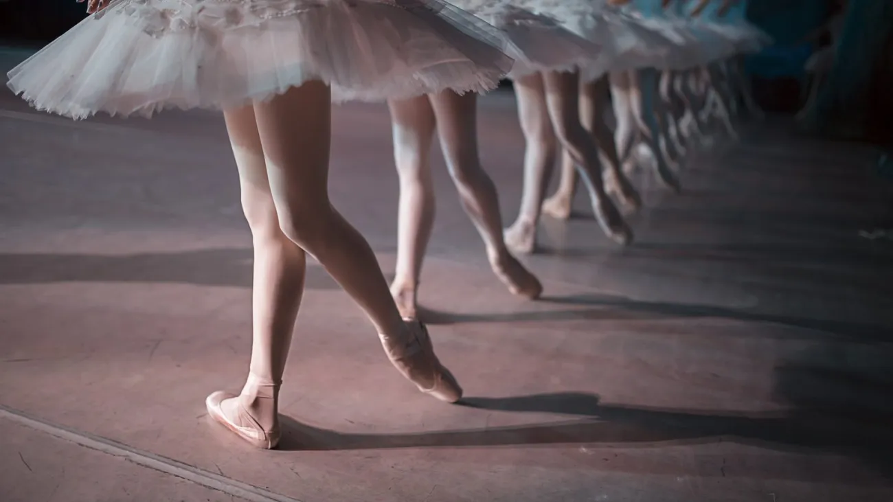Ballet dancers in white tutus dancing in unison