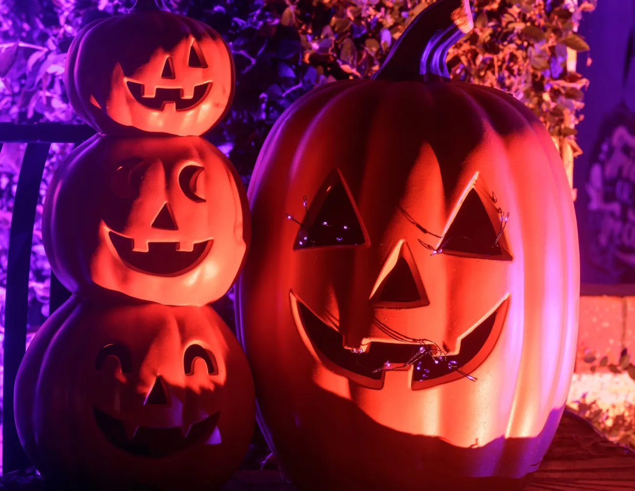 Lit jack-o-lanterns on a porch at night