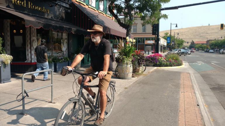Commuting with coffee, an unidentified man rides Missoulas bike-only lanes on Higgins Avenue