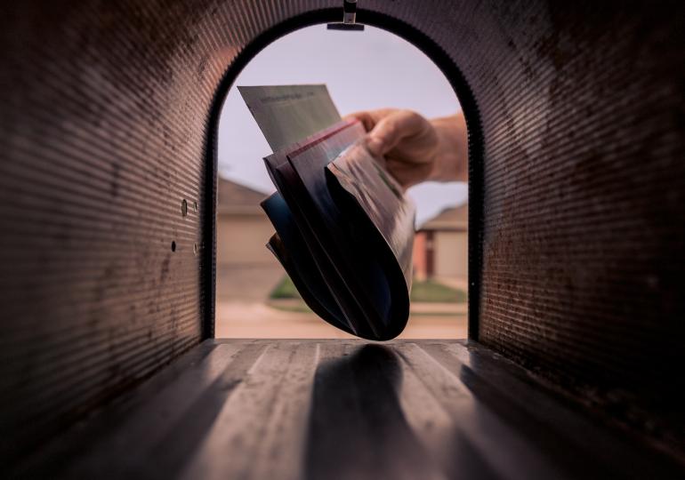 Mail being delivered to a mailbox