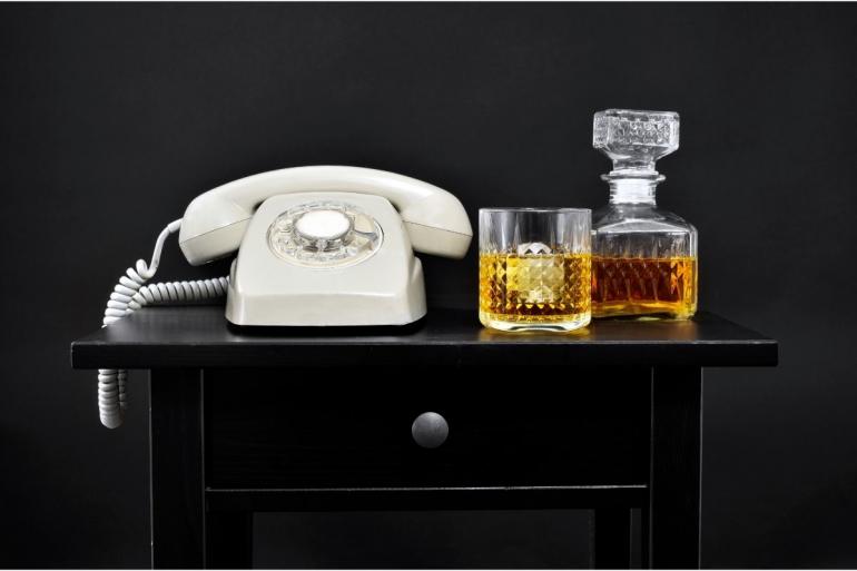 Telephone next to whiskey