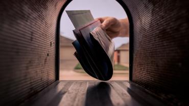 Mail being delivered to a mailbox