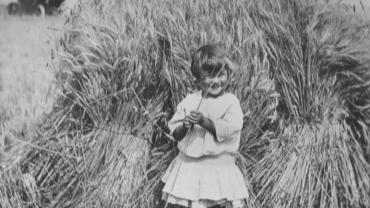 Little girl standing in a wheat field