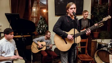 Acoustic band of young men playing and singing on stage