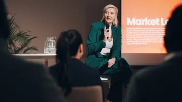 Woman speaking with a microphone at a community talk