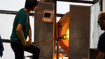 Glassblowing artist working at a furnace
