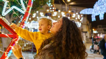 Mother and son admiring Christmas lights at a night market