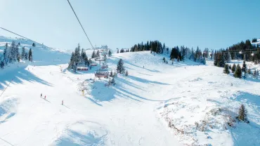 Snowy ski hill with a chairlift and skiers