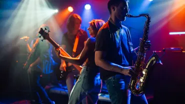 Band playing live on stage under colorful lights