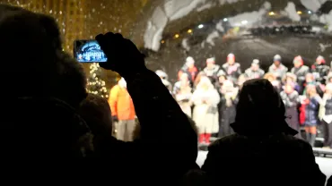 Crowd watching a choir perform on a snowy winter night
