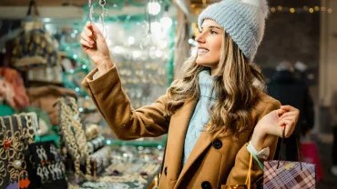 Woman shopping for handmade jewelry at a holiday market