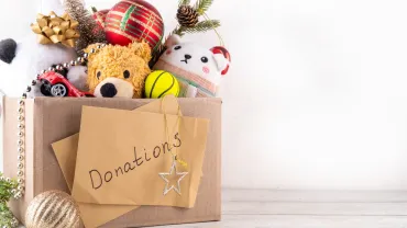 Donating gifts and toys to charity for Christmas holiday concept. Tradition holiday toys drive, cardboard box full with