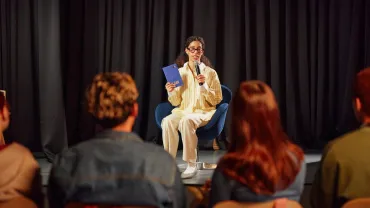 Author speaking on stage with a microphone