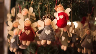 Handmade angel ornament hanging at a holiday market stall