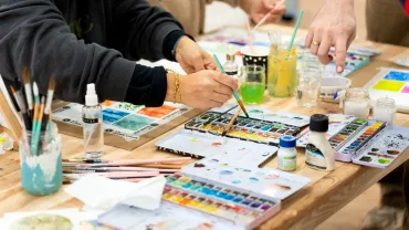 Adults learning watercolor painting in an art class