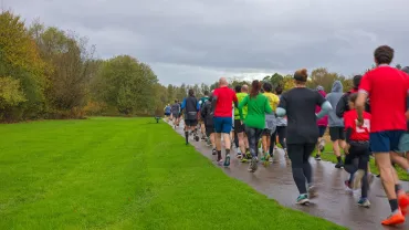 Large group of runners on a road race course