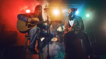 The musician plays an acoustic guitar