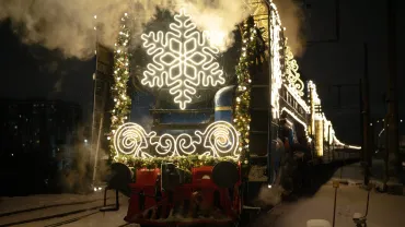 Decorated holiday steam train on snowy tracks