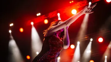 Singer performing on a stage under colorful lights