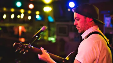 Man playing guitar at a bar
