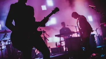 Blurred background light on rock concert with silhouette of musicians