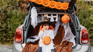 Little child in a witch hat at a trunk or treat