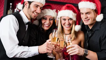 Friends toasting at a Christmas party in a bar