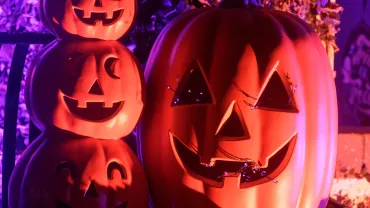 Lit jack-o-lanterns on a porch at night