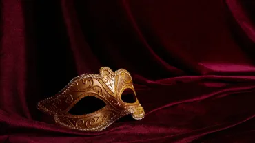 Ornate masquerade mask on a dark red background