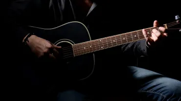 Musician playing acoustic guitar and singing