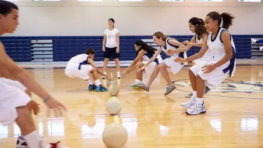 High School Students Playing Dodge Ball In Gym