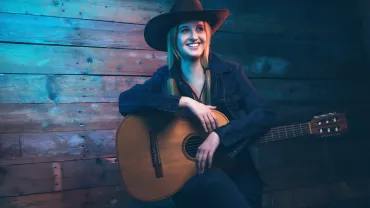 Country singer in a cowboy hat with an acoustic guitar
