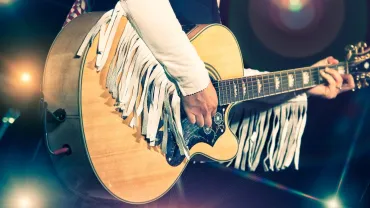 Woman playing guitar with a country band