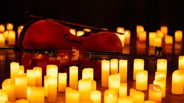 Violin surrounded by glowing candles