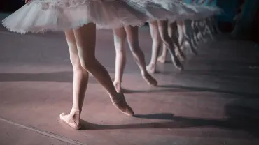 Ballet dancers in white tutus dancing in unison