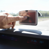 Man touching GPS display in car